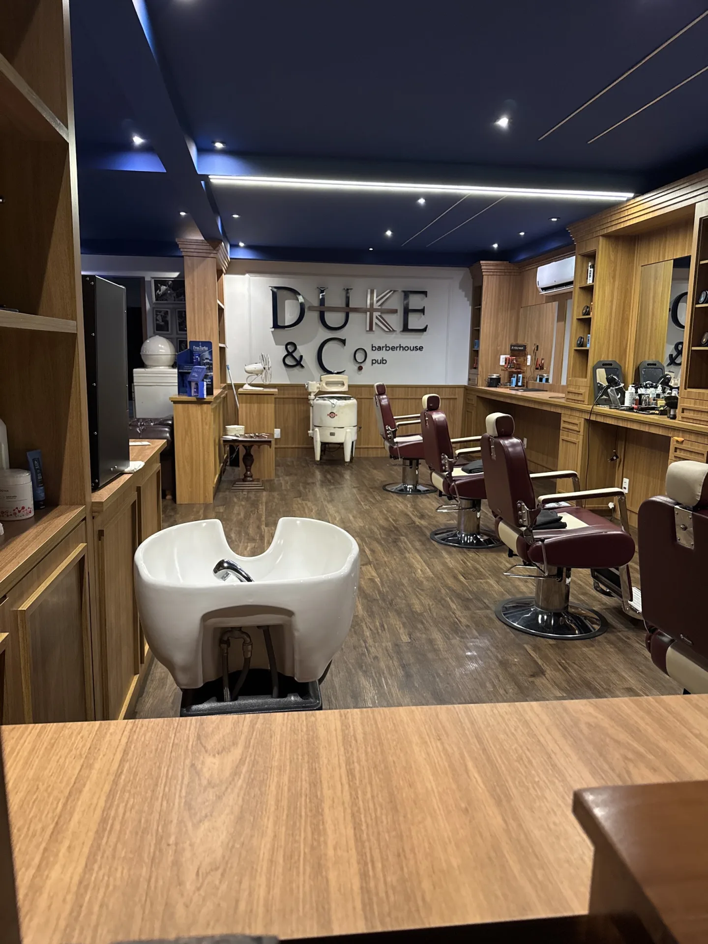 Interior da Barberhouse Duke, com cadeiras e estações de atendimento